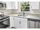 Close up view of a kitchen that features white cabinets, stainless steel appliances and granite countertops at 2536 Nw 3Rd Ave, Ocala, FL 34475