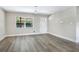 Bright living room with new gray wood floors, a large window, and a fresh coat of neutral paint throughout at 2536 Nw 3Rd Ave, Ocala, FL 34475