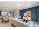Open-concept living space with modern sofa, blue accent wall, and dining area in view at 2582 Winsome Way, Davenport, FL 33896