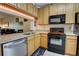 Bright kitchen with wood cabinets, granite countertops, and black appliances at 2935 Greenwood Springs Loop, Lake Mary, FL 32746
