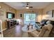 Cozy living room with a ceiling fan, sliding glass doors to a screened-in patio, and comfortable furniture at 2935 Greenwood Springs Loop, Lake Mary, FL 32746