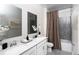 Stylish bathroom features double sinks, white cabinets, modern fixtures, and a shower-tub combination at 314 Puma Loop, Groveland, FL 34736