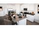 Modern eat-in kitchen boasts stainless steel appliances, white cabinetry, and a stone-topped island at 314 Puma Loop, Groveland, FL 34736