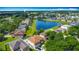 Stunning aerial view of homes surrounding a scenic pond, with blue skies above at 3234 Amberley Park Cir, Kissimmee, FL 34743
