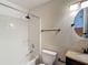 Bright bathroom featuring a shower-tub combo and modern fixtures, with a round mirror over the vanity at 3234 Amberley Park Cir, Kissimmee, FL 34743