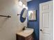 Stylish bathroom featuring granite countertops, bronze fixtures, and a blue accent wall at 3234 Amberley Park Cir, Kissimmee, FL 34743