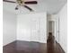 Bedroom with dark floors, neutral walls, ceiling fan, and an open doorway at 3234 Amberley Park Cir, Kissimmee, FL 34743