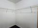 A walk-in closet featuring white wire shelving for ample storage, complemented by dark flooring at 3234 Amberley Park Cir, Kissimmee, FL 34743