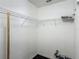 A functional walk-in closet with corner shelving, electrical outlets, and dark wood flooring at 3234 Amberley Park Cir, Kissimmee, FL 34743