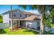 Two-story gray house with a well-kept lawn and garden, exuding curb appeal at 3234 Amberley Park Cir, Kissimmee, FL 34743