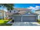 Inviting two-story gray home featuring a spacious three-car garage and lush green lawn at 3234 Amberley Park Cir, Kissimmee, FL 34743