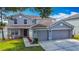 Charming gray two-story home with a three-car garage and a well-manicured lawn at 3234 Amberley Park Cir, Kissimmee, FL 34743