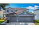 Attractive two-story gray home with a three-car garage and well-maintained landscaping at 3234 Amberley Park Cir, Kissimmee, FL 34743