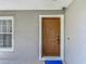 Close-up view of the solid wood front door with a white door frame and security features at 3234 Amberley Park Cir, Kissimmee, FL 34743