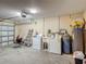 Spacious garage featuring laundry machines, utility sink, and water heater at 3234 Amberley Park Cir, Kissimmee, FL 34743