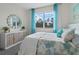 Charming bedroom featuring a large window, turquoise accents, and decorative cabinet at 3318 Arch Ave, Ormond Beach, FL 32174