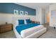 Cozy bedroom featuring blue accent wall, neutral carpet, and minimalist decor at 3318 Arch Ave, Ormond Beach, FL 32174