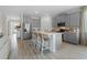 Bright kitchen features gray cabinets, stainless steel appliances, and a spacious center island with seating at 3318 Arch Ave, Ormond Beach, FL 32174