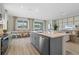 Open kitchen with gray cabinets, an island and view into the dining and living areas at 3318 Arch Ave, Ormond Beach, FL 32174