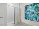 Bathroom featuring a white tiled shower with a glass door and modern artwork at 3326 Arch Ave, Ormond Beach, FL 32174