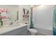 Bright bathroom with a shower and tub combo, light gray vanity, and a modern beachy-themed decoration at 3326 Arch Ave, Ormond Beach, FL 32174