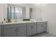 Bathroom with double vanity sinks, gray cabinets, and quartz countertops at 3326 Arch Ave, Ormond Beach, FL 32174