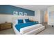 Bedroom with a blue accent wall, comfortable bed, and view into the doorway at 3326 Arch Ave, Ormond Beach, FL 32174