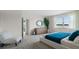 Spacious bedroom with a dresser, round mirror, large window, and inviting decor at 3326 Arch Ave, Ormond Beach, FL 32174