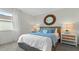 Cozy bedroom featuring a large window, stylish nightstands with lamps, and a decorative round mirror at 3326 Arch Ave, Ormond Beach, FL 32174