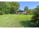 Backyard view of home featuring large lawn, mature trees, and screened in patio at 33925 Highland Rd, Leesburg, FL 34788