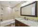 Bathroom featuring a vanity with granite countertop, decorative mirror and tiled tub and shower at 33925 Highland Rd, Leesburg, FL 34788
