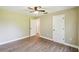 Light-filled bedroom featuring wood-look flooring and multiple doors for easy access to other areas at 33925 Highland Rd, Leesburg, FL 34788