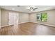 Large bedroom with wood-look floors, neutral paint, and a view of trees through a window at 33925 Highland Rd, Leesburg, FL 34788