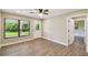 Bright bedroom featuring wood-look floors, natural light, and access to the backyard at 33925 Highland Rd, Leesburg, FL 34788