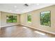 Bright bedroom with hardwood floors and large windows offering scenic views at 33925 Highland Rd, Leesburg, FL 34788