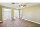Bright bedroom features wood-look flooring, neutral paint, ceiling fan, and walk-in closets at 33925 Highland Rd, Leesburg, FL 34788