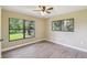 Bright, airy bedroom with wood-look floors and large windows overlooking a lush yard at 33925 Highland Rd, Leesburg, FL 34788