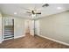 Spacious bedroom with wood-look flooring, ceiling fan, and white trim, next to stairs at 33925 Highland Rd, Leesburg, FL 34788