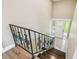 Entryway featuring wood and tile flooring, wrought iron railing and a front door with decorative glass at 33925 Highland Rd, Leesburg, FL 34788