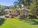Front exterior view of home with lawn, tropical plants, and palm trees at 33925 Highland Rd, Leesburg, FL 34788