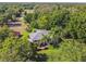 Eye-level exterior featuring a home nicely landscaped with palm trees and green lawn surrounded by tall trees at 33925 Highland Rd, Leesburg, FL 34788