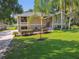 Front exterior view of home with mature trees, lawn, and lush landscaping at 33925 Highland Rd, Leesburg, FL 34788