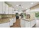 Bright kitchen features white cabinets, stainless appliances, an island and granite countertops at 33925 Highland Rd, Leesburg, FL 34788
