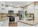 Bright kitchen features white cabinets, stainless appliances, an island and granite countertops at 33925 Highland Rd, Leesburg, FL 34788