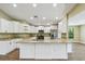Bright kitchen features white cabinets, stainless appliances, an island and granite countertops at 33925 Highland Rd, Leesburg, FL 34788
