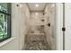 Tiled walk-in shower features a pebble floor, built-in bench, and decorative accents, for spa-like experience at 33925 Highland Rd, Leesburg, FL 34788