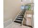 A bright staircase features dark wood treads, white risers and a decorative iron handrail, leading to the second floor at 33925 Highland Rd, Leesburg, FL 34788