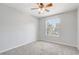 Well-lit bedroom with neutral carpet and walls, a window offering natural light, and a ceiling fan at 3539 Foxcroft Cir, Oviedo, FL 32765
