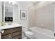 Well-lit bathroom featuring modern fixtures, neutral tiling, and a bathtub-shower combination at 3814 Blue Vale Dr, Davenport, FL 33837
