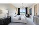 Luxurious bedroom featuring a tufted headboard, chandelier, and large window with beautiful outdoor views at 3814 Blue Vale Dr, Davenport, FL 33837